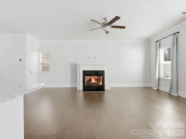 an empty room with windows and fireplace