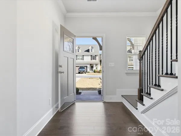 a view of a hallway with entryway and wooden floor