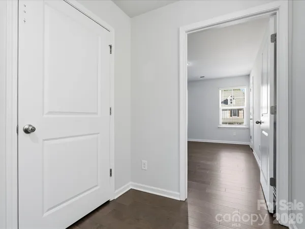an empty room with a wooden floor and windows