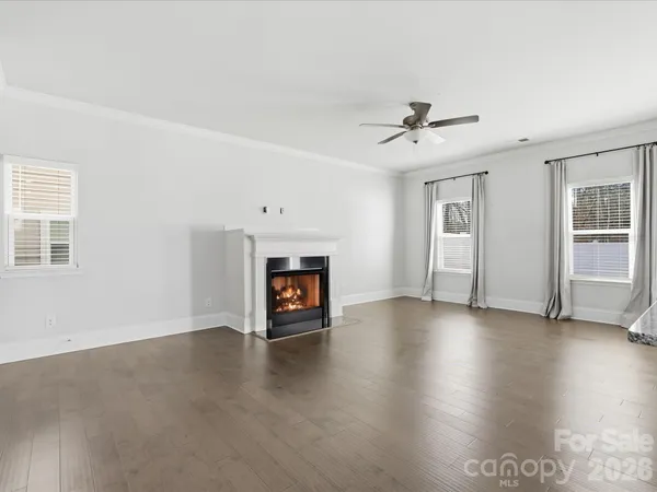 an empty room with windows and fireplace