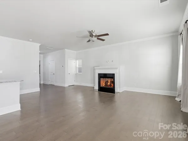 a view of an empty room with a ceiling fan and a window