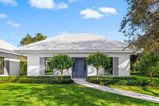 a view of swimming pool with seating space and trees in the background
