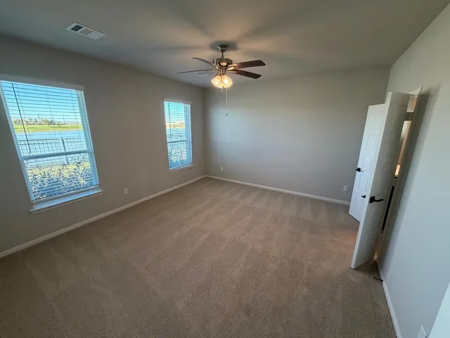 a view of a livingroom with a ceiling fan and window