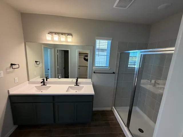 a bathroom with a double vanity sink and a mirror