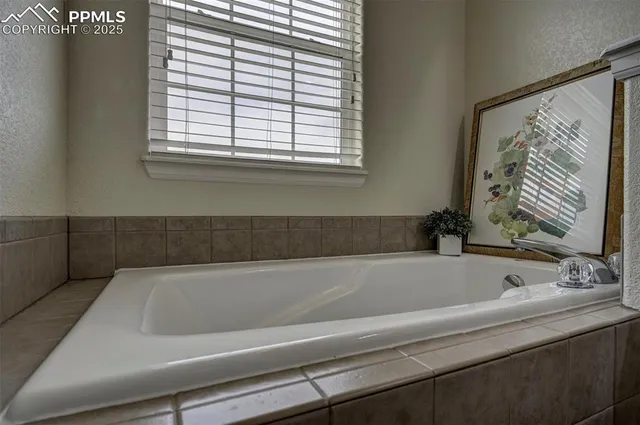 a bathroom with a bathtub and next to a window