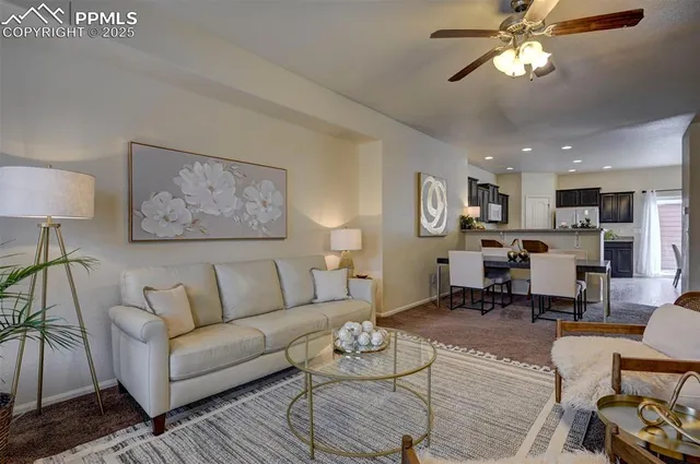 a living room with furniture kitchen view and a chandelier