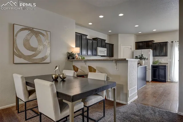 a kitchen with a dining table cabinets and stainless steel appliances