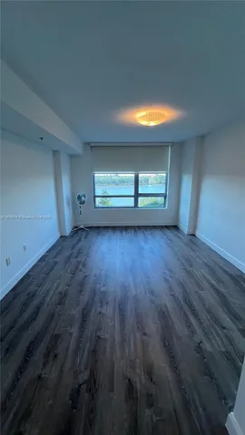 a view of room with window and wooden floor