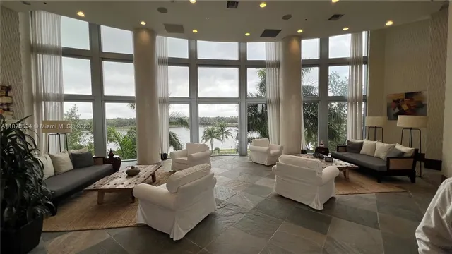 a living room with furniture and floor to ceiling windows