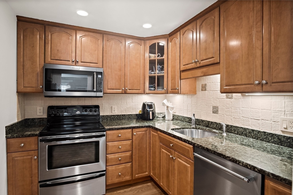 386 Great Road, Unit A8 Acton, MA 01720 - Photo 9 of 26 a kitchen with granite countertop a sink stainless steel appliances and cabinets