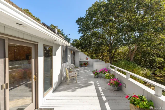 a balcony with wooden floor and outdoor seating
