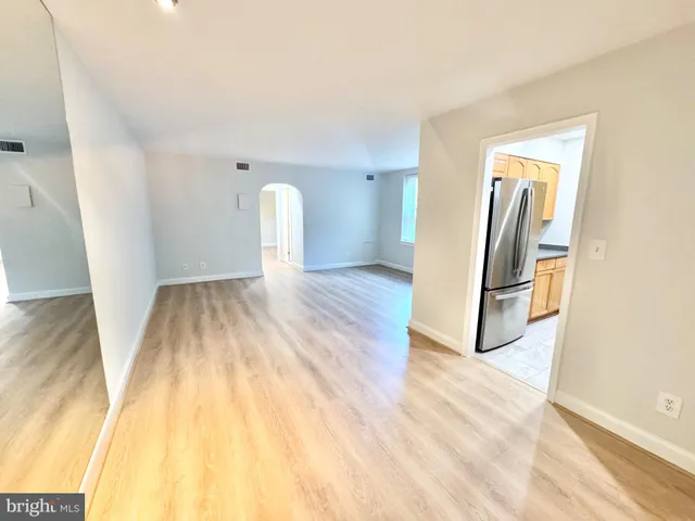 a view of a room with wooden floor and a hallway