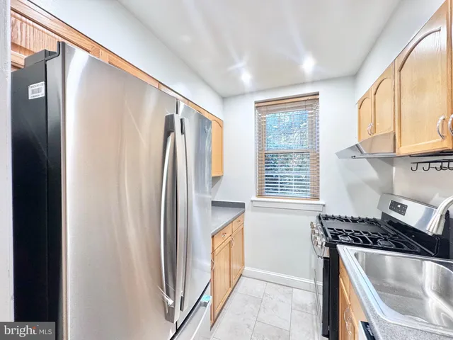 a kitchen with stainless steel appliances granite countertop a refrigerator and a stove