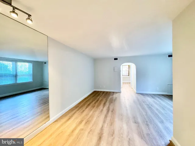 a view of a room with wooden floor and window