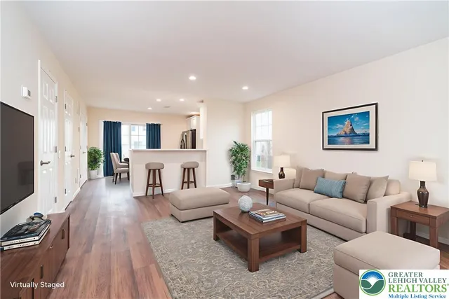 a living room with furniture wooden floor and a flat screen tv