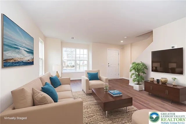 a living room with furniture a flat screen tv and a large window