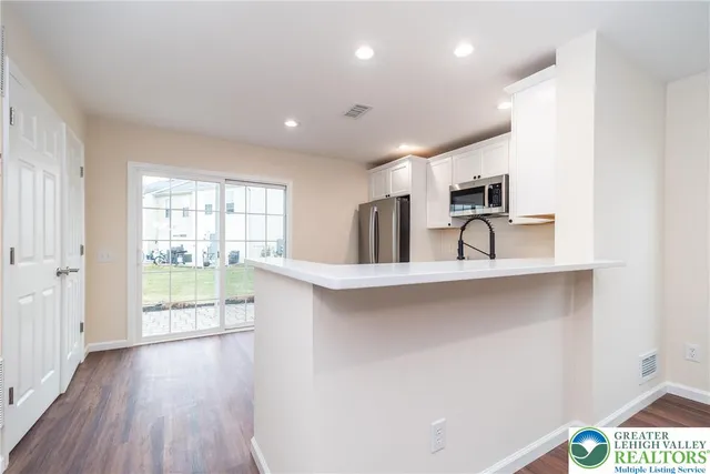 a view of a kitchen with furniture and wooden floor