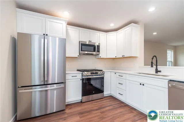 a kitchen with stainless steel appliances a refrigerator sink and microwave
