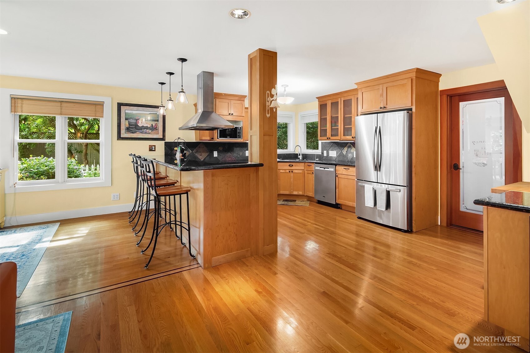 7732 195th Street Southwest Edmonds, WA 98026 - Photo 5 of 39 a kitchen with stainless steel appliances a refrigerator a stove a dining table and chairs with wooden floor