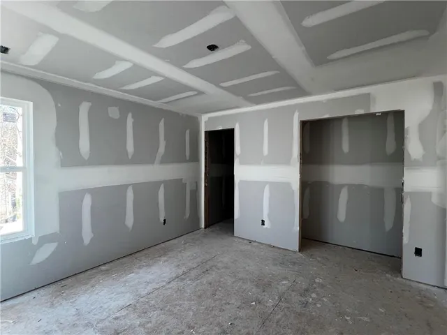 an empty room with windows and closet