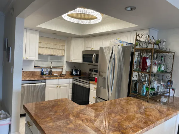 a kitchen with stainless steel appliances granite countertop a refrigerator stove top oven and sink