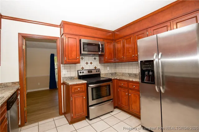 a kitchen with stainless steel appliances granite countertop a stove microwave and refrigerator