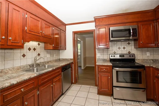 a kitchen with stainless steel appliances granite countertop a refrigerator and a stove