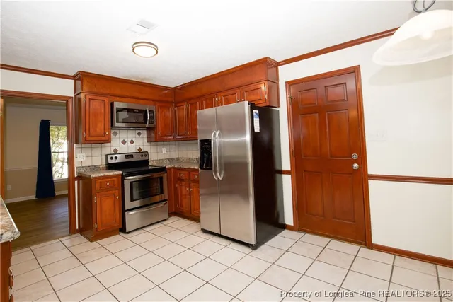 a kitchen with stainless steel appliances granite countertop a refrigerator and a sink