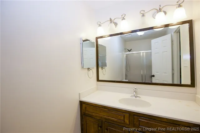 an empty room with wooden floor and fan