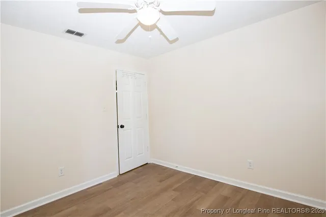 a view of small space with wooden floor and a chandelier fan