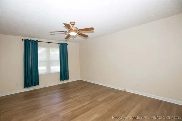 a view of a big room with wooden floor and windows