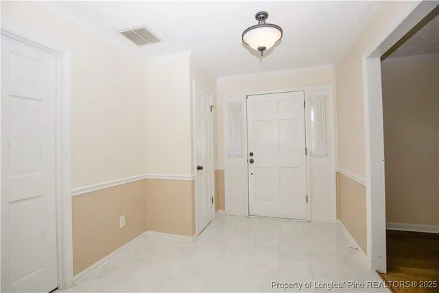 a view of a hallway with wooden floor and a bathroom