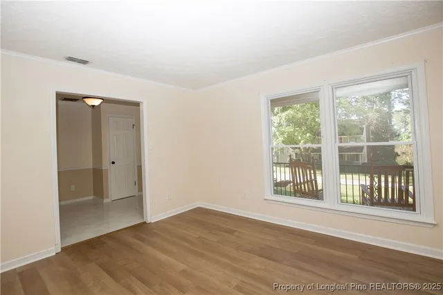a view of empty room with wooden floor