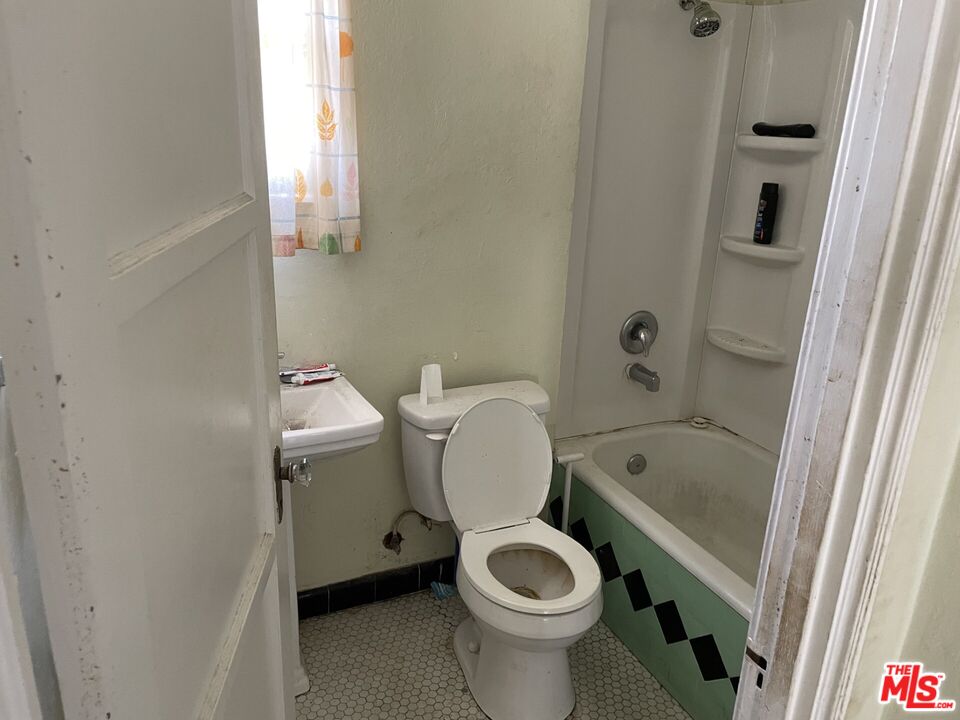 1920 South Rimpau Boulevard Los Angeles, CA 90016 - Photo 21 of 25 a white toilet sitting next to a bath tub
