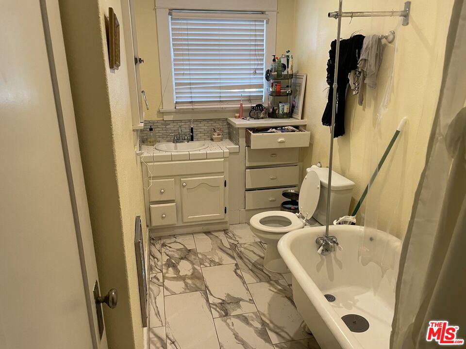 1920 South Rimpau Boulevard Los Angeles, CA 90016 - Photo 8 of 25 a bathroom with a sink and mirror with bathtub