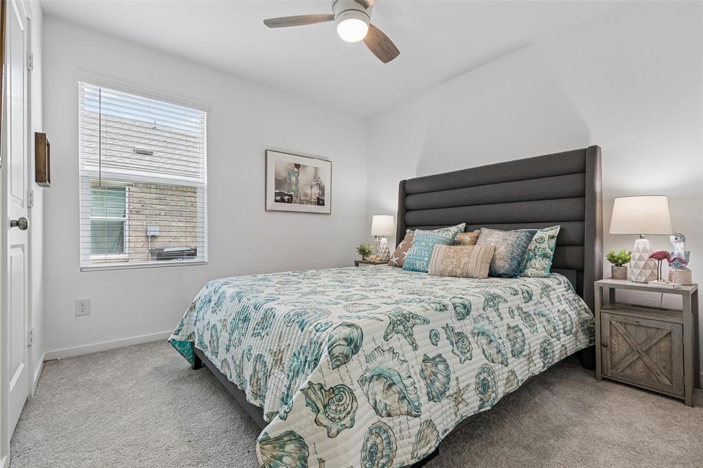 14163 Kempt Drive Pilot Point, TX 76258 - Photo 16 of 29 This comfortable secondary bedroom features plush carpeting, a ceiling fan, and a large window that fills the space with natural light. Conveniently located just across the hall from the full secondary bathroom, it offers the perfect setup for family members, guests, or a home office.