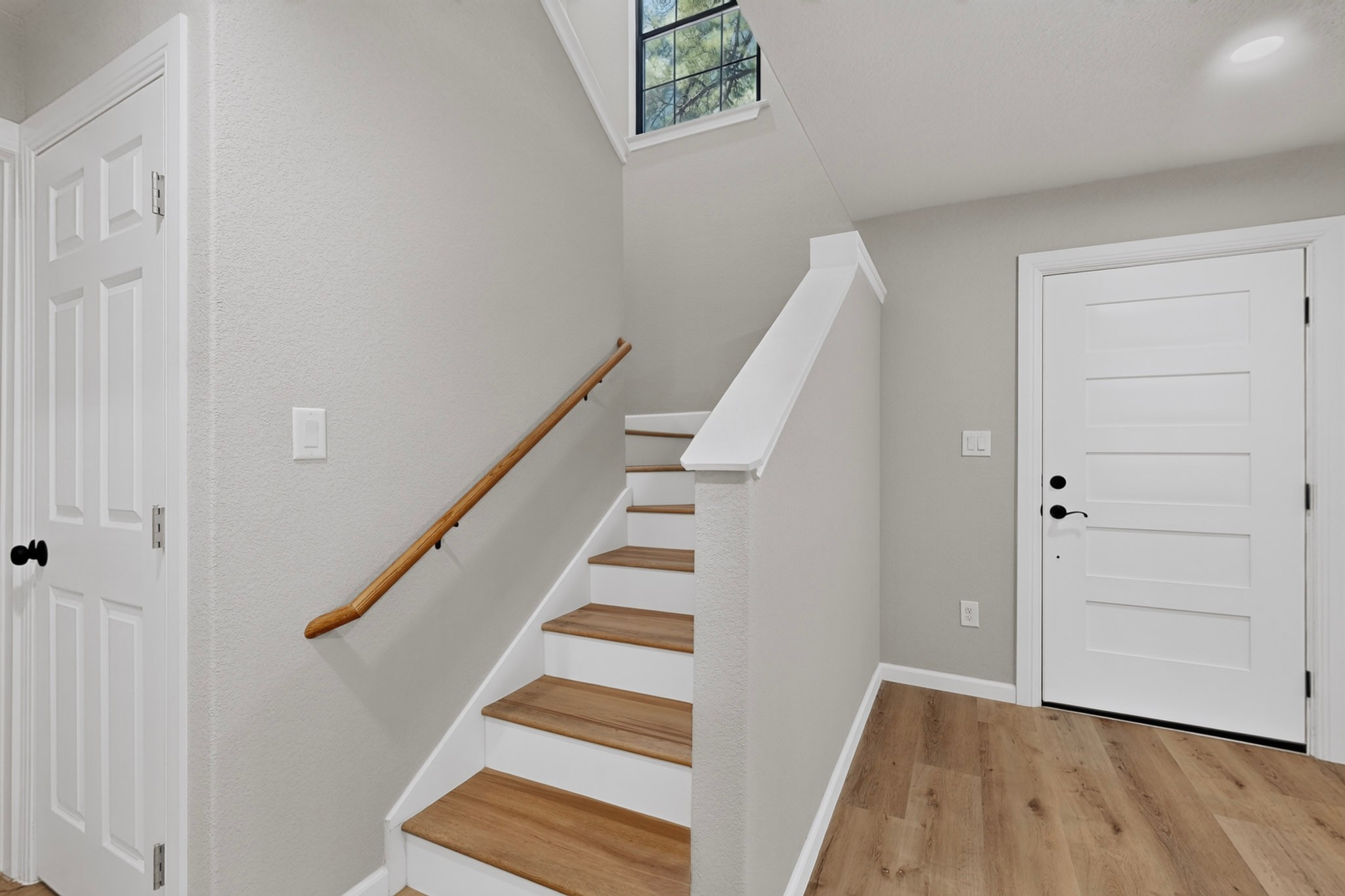 158 Fealy Road Red Rock, TX 78662 - Photo 9 of 40 An inviting entryway presents a warm wood-accented staircase and resilient laminate flooring.
