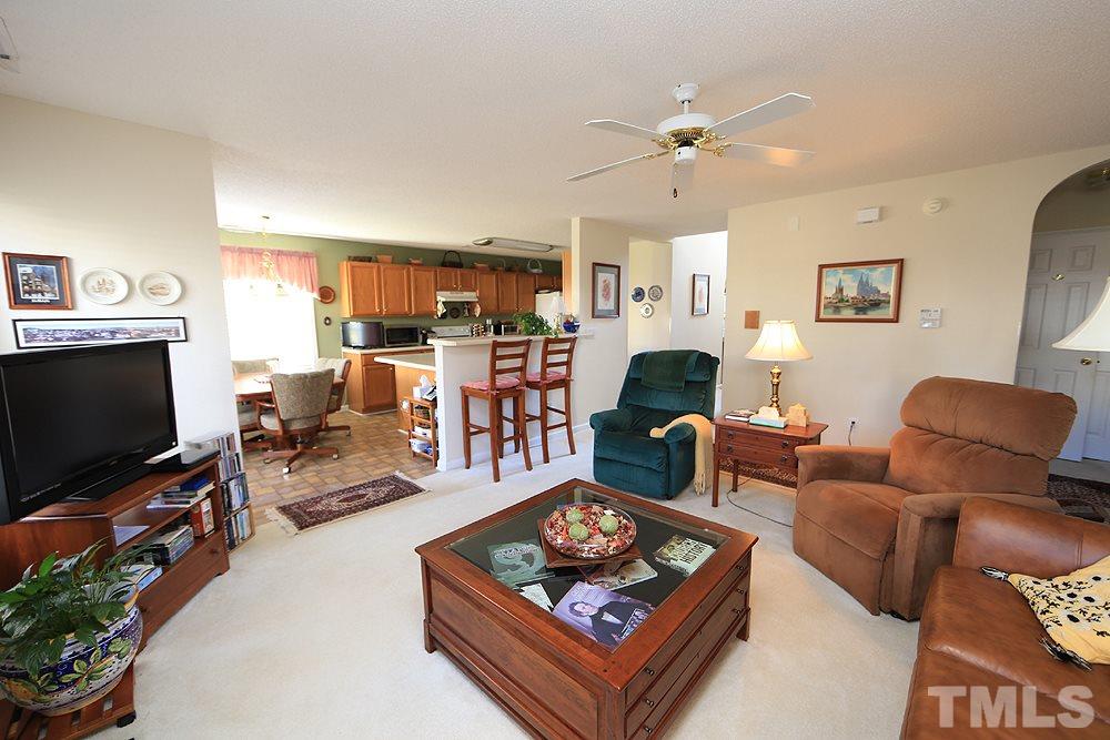 4707 Drewbridge Way Raleigh, NC 27604 - Photo 11 of 28 a living room with furniture a flat screen tv and a fireplace