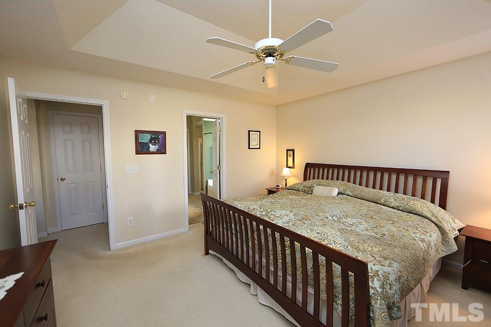4707 Drewbridge Way Raleigh, NC 27604 - Photo 17 of 28 a bedroom with a bed and a chandelier