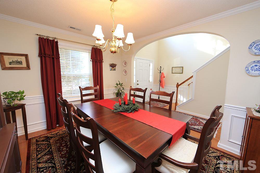 4707 Drewbridge Way Raleigh, NC 27604 - Photo 6 of 28 a view of a dining room with furniture a chandelier and wooden floor