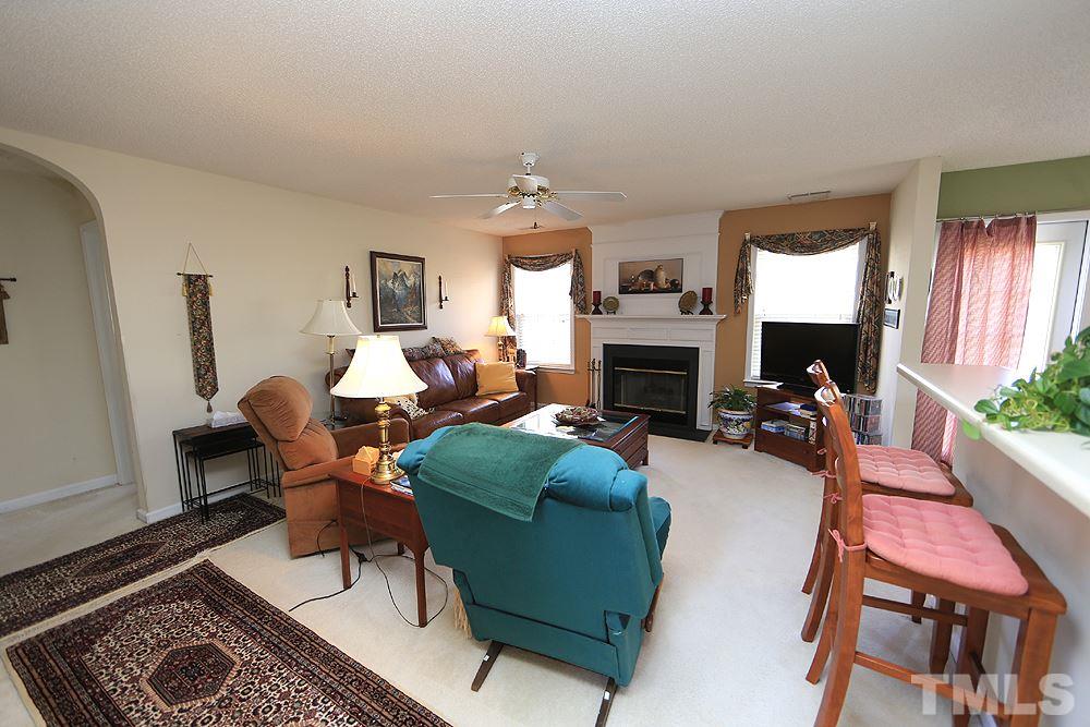 4707 Drewbridge Way Raleigh, NC 27604 - Photo 7 of 28 a living room with furniture a fireplace and a window