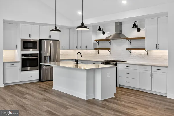 a kitchen with stainless steel appliances granite countertop a sink a stove and a refrigerator