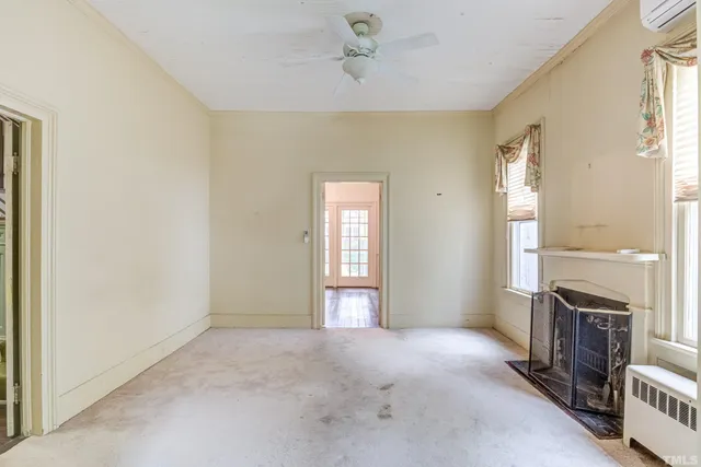 a kitchen with granite countertop a refrigerator a sink and white cabinets