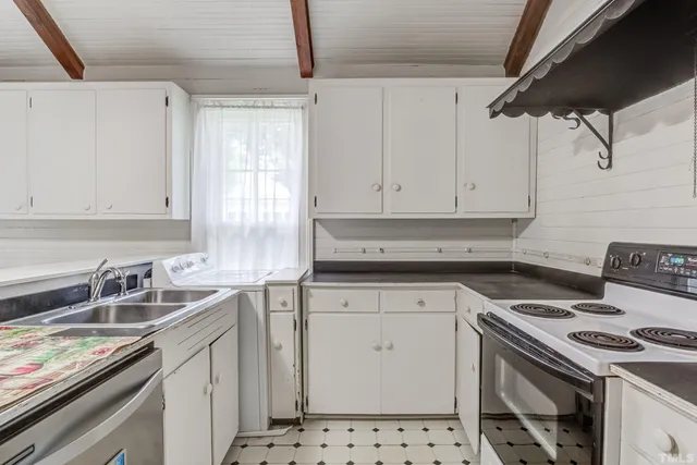 a kitchen with stainless steel appliances a table and chairs in it