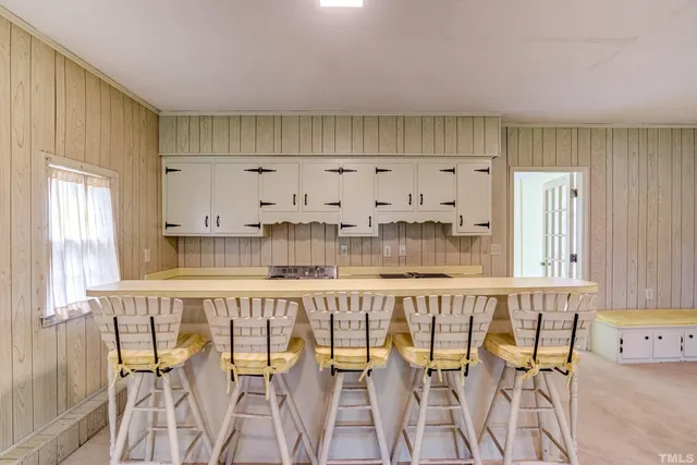 an empty room with windows and cabinet