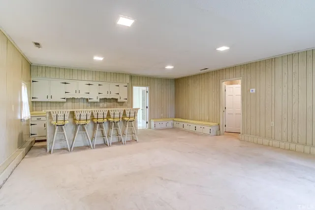 an empty room with wooden floor fireplace and windows
