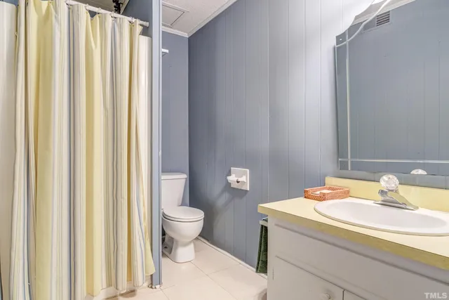 a bathroom with a granite countertop sink mirror and a toilet
