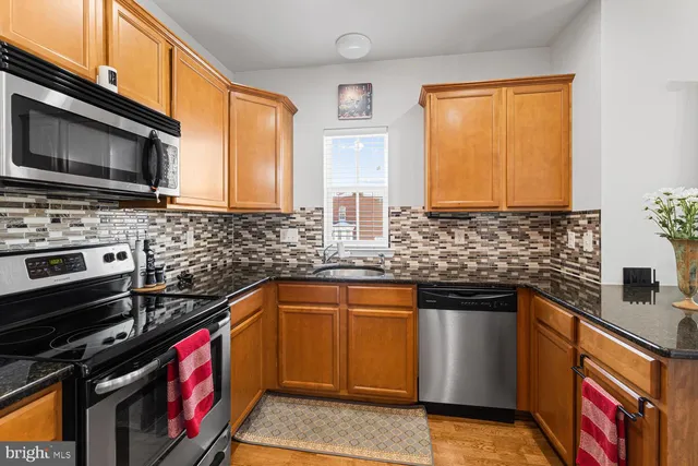 a kitchen with stainless steel appliances a stove sink microwave and cabinets