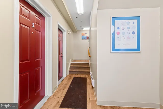 a view of a hallway with wooden floor and stairs