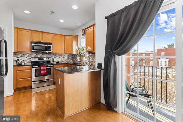 a kitchen with stainless steel appliances granite countertop a refrigerator and a stove
